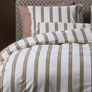 closer view: Close-up of Dune striped ivory duvet cover folded back beneath a matching pillow